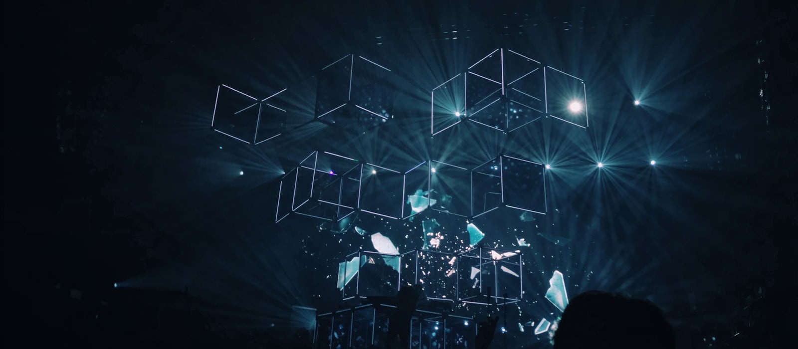 Wireframe cubes suspended in a dark space, lit from behind.